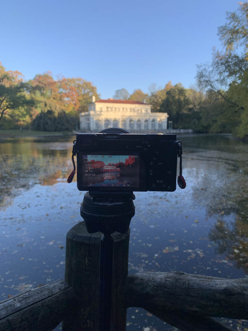 A photo of a Sony a6300 taking a time lapse or hyperlapse of the boathouse in Prospect Park Brooklyn New York on a cloudless blue fall day.