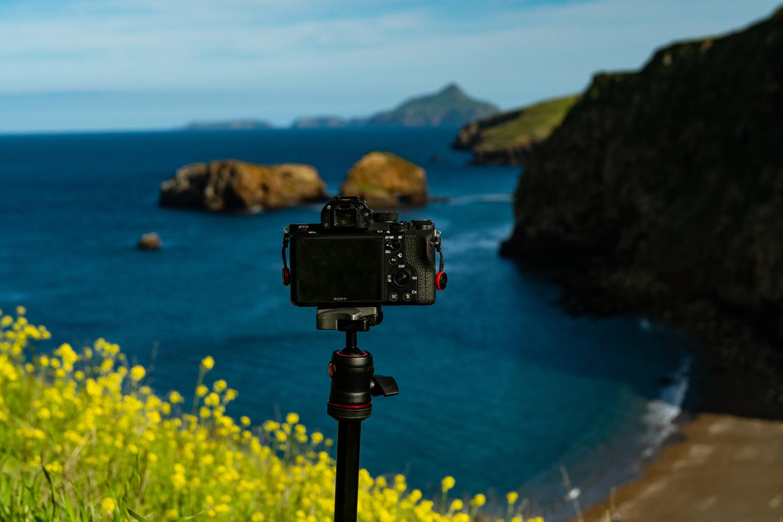 A visual of a camera on a tripod overlooking the coastal cliffs of the channel islands in California as a place holder for an example of what is time lapse photography.