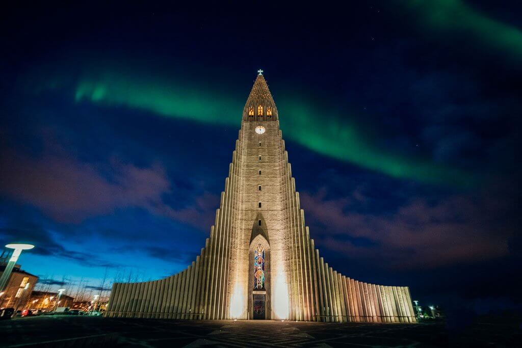 A picture of the church in Reyjkavic Iceland with the auroroa borealis in the sky that is a subject of a hyperlapse.
