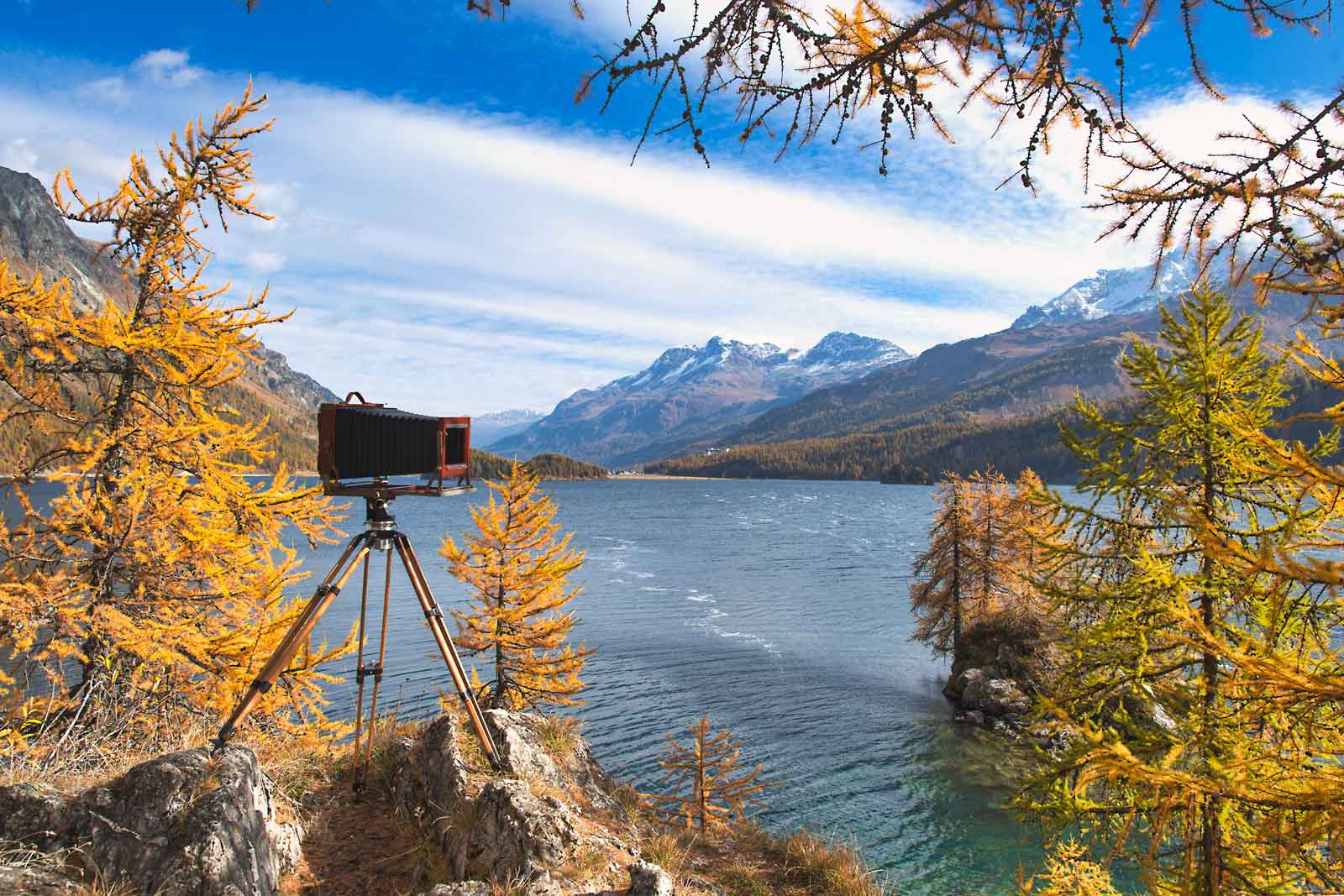 Antique plate camera on wooden tripod during a landscape photo as an example of what is time lapse.