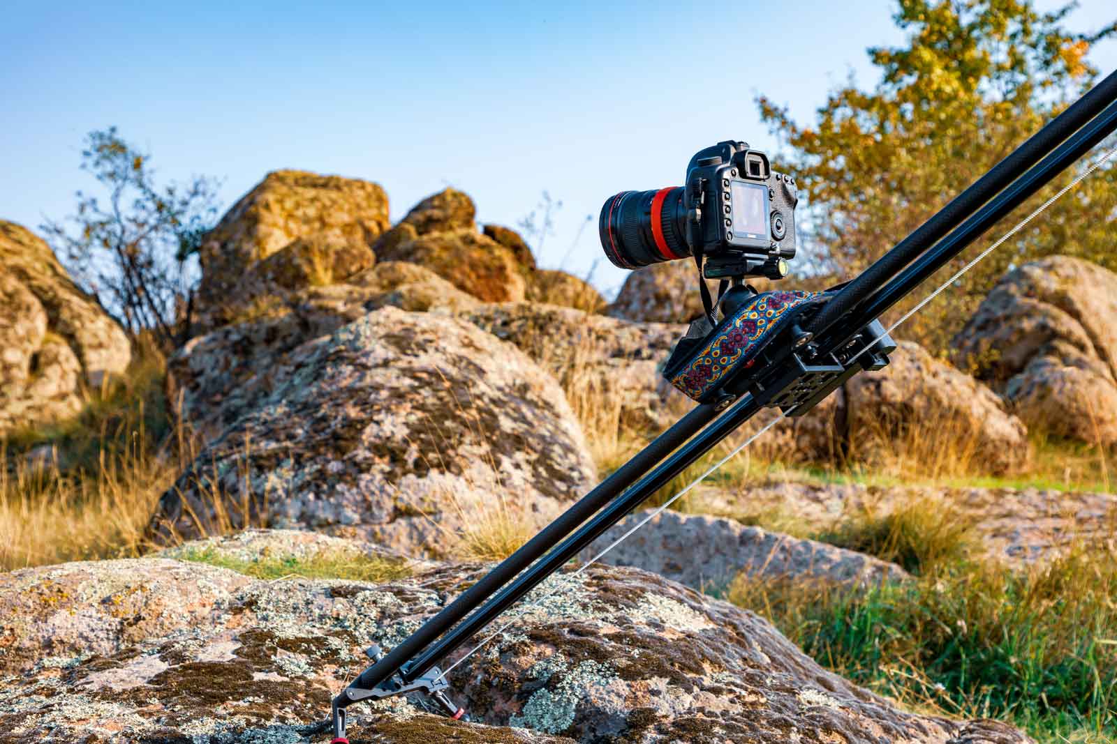 A DSLR on a motion control slider as an illustration for movement on an article discussing what is time lapse photography?