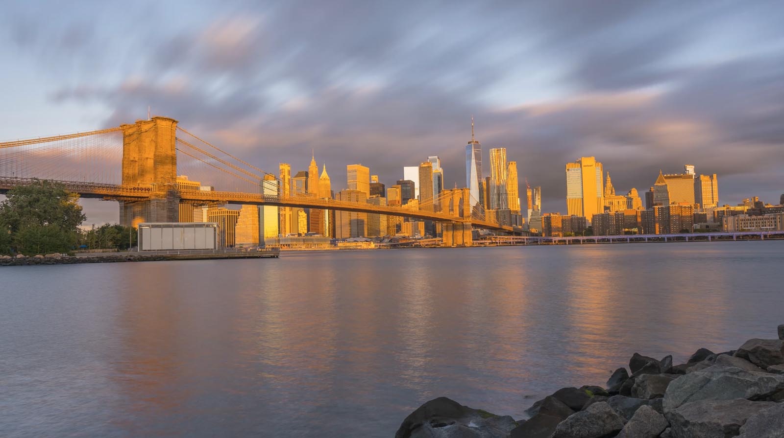 A photo of the Manhattan Skyline from Brooklyn at golden hour sunrise.